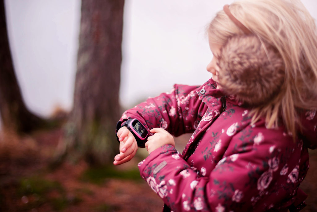 Barn snakker inn i sin Xplora smartklokke ute om vinteren